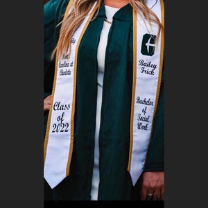 May include: White graduation sash with gold trim and black text. The text reads "University of North Carolina at Charlotte", "Class of 2022", "Bailey Frick", "Bachelor of Social Work".