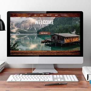May include: A computer screen displaying a website with a wooden background and a picture of a lake and a cabin. The website text reads "Welcome to our place" and "Book your stay".