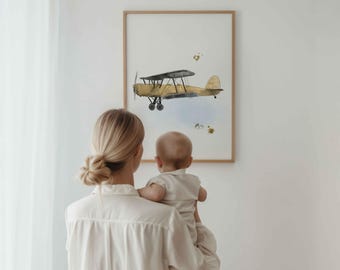 May include: A framed wall art print featuring a watercolor illustration of a vintage biplane in shades of yellow and black, set against a white background with subtle blue watercolor accents and small gold-toned paint splatters.