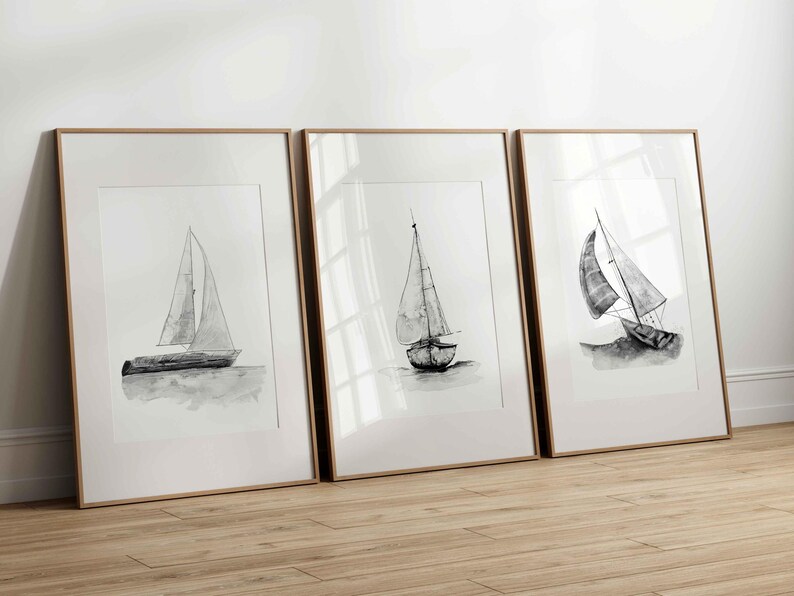 May include: Three framed black and white illustrations of sailboats on a white background. The frames are light wood.