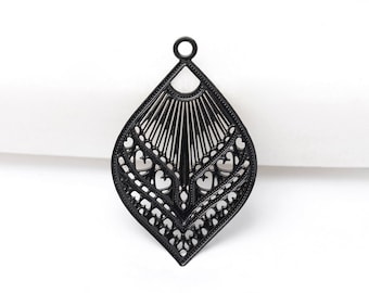 May include: Black filigree pendant in a teardrop shape. The pendant features a detailed openwork design with heart and line patterns. A small loop is at the top for attaching to a chain or earring hook. The pendant is set against a white background.