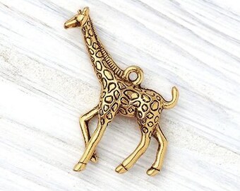 May include: A gold-colored giraffe charm with a detailed spotted pattern. The charm is made of metal and has a loop at the top for attaching to a necklace or bracelet. The giraffe is standing on all fours.