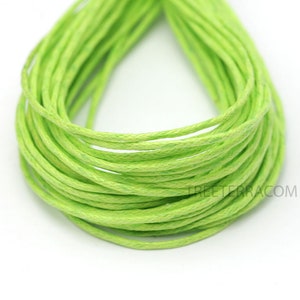 May include: A bundle of bright green, tightly wound cord. The cord appears to be made of a woven material, and is a vibrant, solid green color. The cord is likely used for crafting or jewelry making.