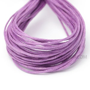 May include: A bundle of lavender-colored waxed cotton cord, tightly coiled. The cord appears smooth and uniform in color, suitable for various crafting projects. The background is plain white, highlighting the cord's color and texture.