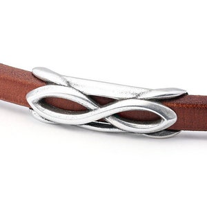 May include: A brown leather bracelet with a silver-coloured infinity symbol clasp. The bracelet is made of a thin strip of leather. The clasp is a decorative element.