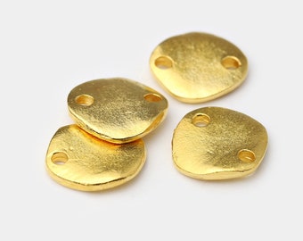 May include: Four gold-colored, irregular-shaped metal connectors with two holes each. The connectors have a textured surface and a bright, shiny finish. They are likely used for jewelry making or other craft projects.