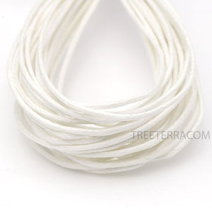 May include: Close-up of a bundle of white cotton cord. The cord is tightly wound, creating a layered effect. The texture appears soft and slightly textured. The image is well-lit, highlighting the cord's color and form. The website treeterra.com is visible.