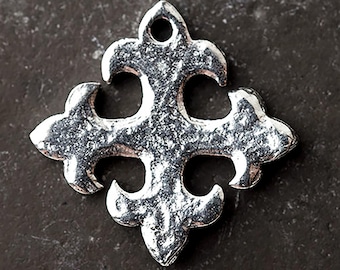 May include: A silver-colored, fleur-de-lis shaped pendant with a textured surface. The pendant has a hole at the top for stringing and a cross-like design with four curved arms. The metal has a slightly aged appearance.