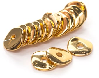 May include: A collection of shiny, gold-colored beads with a flat, irregular shape and a central hole. The beads are arranged in a line and scattered, reflecting light. These beads are suitable for jewelry making.