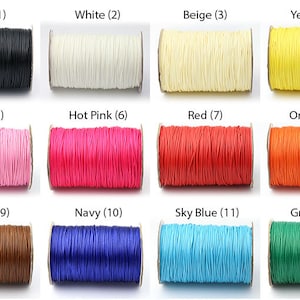 May include: A selection of cord spools in a range of colours: black, white, beige, yellow, pink, hot pink, red, orange, brown, navy, sky blue, and green. Each spool is numbered for identification.