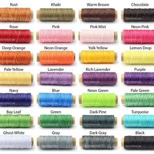 May include: A collection of colorful spools of waxed thread, each labeled with a different color name. Colors include rust, khaki, warm brown, chocolate, rose, pink, pink mist, neon pink, deep orange, neon orange, yolk yellow, lemon drop, pale yellow, lavender, rich lavender, purple, navy, blue, neon green, pale green, bay leaf, green, dark pine, turquoise, ghost white, gray, dark gray, and black.