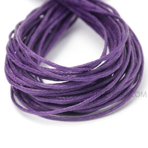 May include: A bundle of purple waxed cotton cord, tightly coiled. The cord appears to be a deep shade of purple, with a slightly textured surface. This craft supply is suitable for jewelry making and other DIY projects.