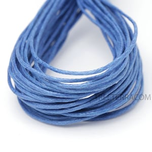 May include: A close-up of a bundle of blue waxed cotton cord. The cord is tightly wound, revealing a textured surface. The color is a vibrant, medium blue, suitable for various crafting projects.