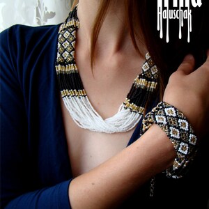 May include: A woman wearing a black and white beaded necklace and a black and white beaded bracelet. The necklace and bracelet have gold accents. The text "Irina Haluschak" is visible in the image.
