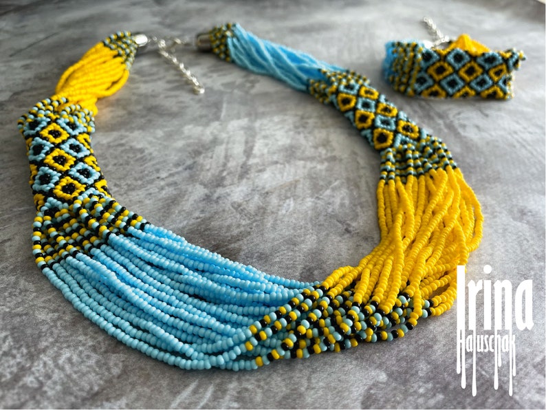 May include: A beaded necklace and bracelet set in blue, yellow, and black. The necklace is long and has a geometric pattern. The bracelet is shorter and has a similar pattern.
