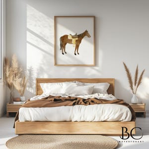 May include: A watercolor painting of a brown horse with a saddle, framed in a light wood frame and hanging on a white wall above a bed with brown bedding.