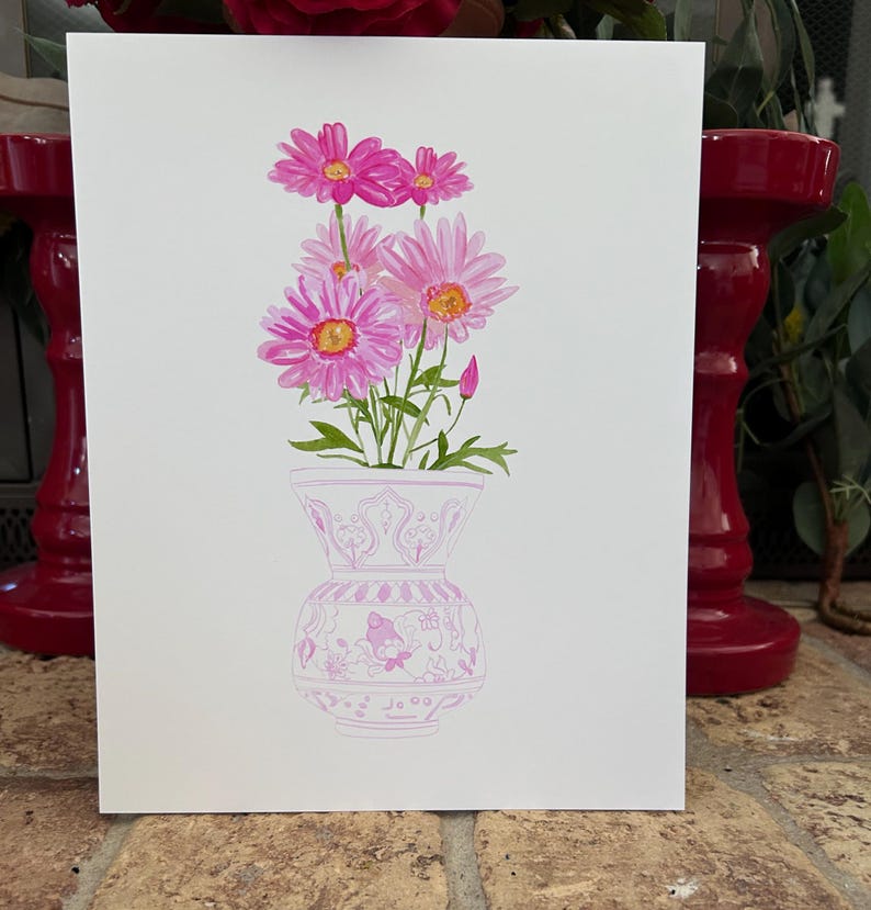 May include: A watercolor painting of a bouquet of pink daisies in a pink and white patterned vase.