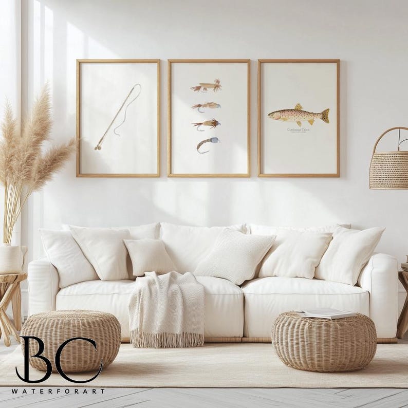 May include: Three framed prints on a white wall above a white couch with two beige ottomans. The prints are of fishing flies, a fishing rod, and a trout. The text on the print reads "Cutthroat Trout".