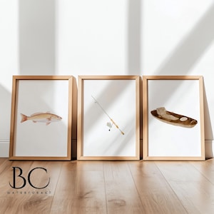 May include: Three framed watercolor illustrations of fishing-themed imagery. The first image shows a redfish, the second image shows a fishing rod, and the third image shows a brown canoe.