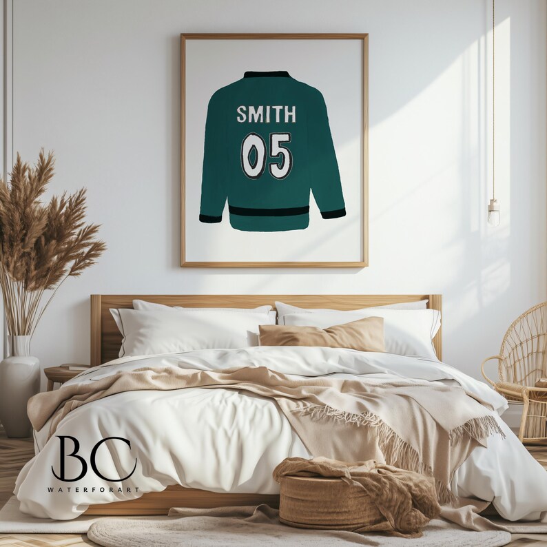 Puede incluir: Una chaqueta verde azulada con el nombre "SMITH" y el n&uacute;mero "05" en blanco en la parte posterior. La chaqueta est&aacute; colgada en una pared blanca en un dormitorio.