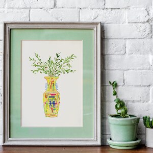 May include: A framed watercolor painting of a yellow vase with green leaves and red berries. The vase has a colorful geometric pattern.