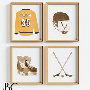 Pu&ograve; includere: Quattro illustrazioni ad acquerello incorniciate di attrezzatura da hockey. L'immagine in alto a sinistra mostra una maglia da hockey gialla con il nome "SMITH" e il numero "05" sul retro. L'immagine in alto a destra mostra un casco da hockey marrone con una gabbia. L'immagine in basso a sinistra mostra un paio di pattini da hockey marroni. L'immagine in basso a destra mostra due bastoni da hockey incrociati con un disco.
