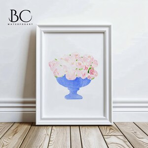May include: A watercolour painting of a bouquet of pink flowers in a blue vase. The vase has a scalloped rim and a pedestal base. The flowers are arranged in a loose, natural style.