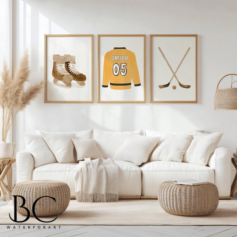 Puede incluir: Tres impresiones de acuarela enmarcadas con un tema de hockey. Las impresiones muestran un par de patines de hockey, una camiseta de hockey con el nombre "Smith" y el n&uacute;mero "05", y un par de palos de hockey cruzados.