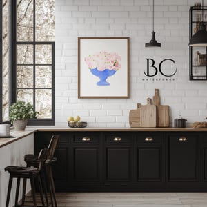 May include: A watercolour painting of a blue vase filled with pink flowers. The painting is framed and hanging on a white brick wall in a kitchen setting. The text "BC WATERFORART" is visible below the painting.