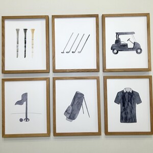 May include: Six framed prints with a golf theme. The prints feature a golf cart, golf clubs, a golf bag, a golf flag, golf tees, and a golf shirt.