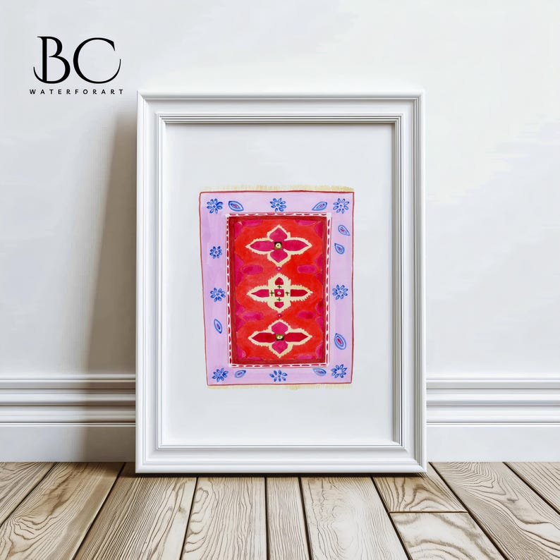 May include: A framed watercolor painting of a pink and red rug with a blue and white pattern. The rug is surrounded by a white frame.