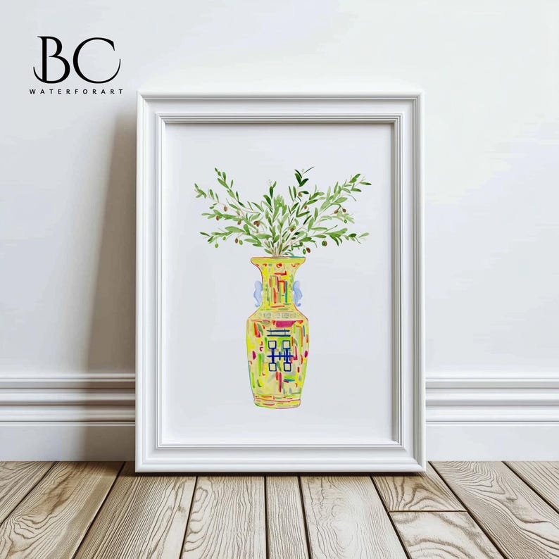 May include: A watercolor painting of a yellow vase with a colorful geometric pattern, filled with green olive branches. The vase is in a white frame against a white wall.