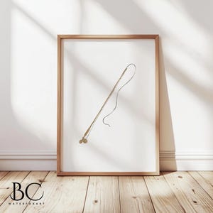 May include: A framed print of a black and white line drawing of a fishing rod with a reel. The rod is angled upwards and the line is curved. The print is on a white background and is framed in a light wood frame.