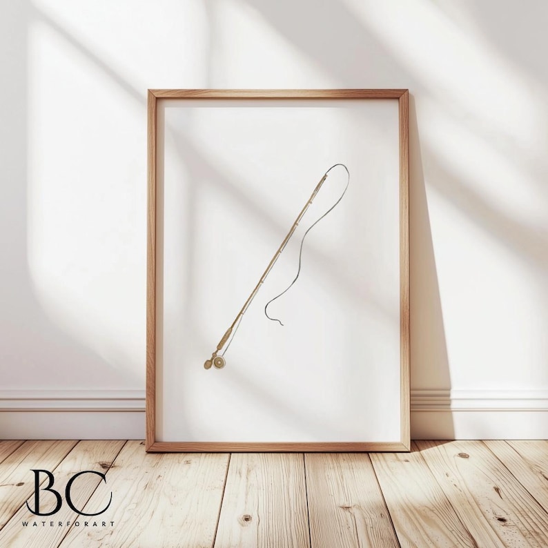 May include: A framed print of a black and white line drawing of a fishing rod with a reel. The rod is angled upwards and the line is curved. The print is on a white background and is framed in a light wood frame.