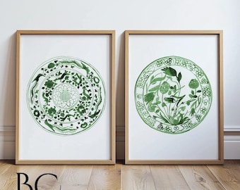 May include: Two framed prints of green and white watercolor illustrations of Chinese porcelain plates with floral and bird designs.