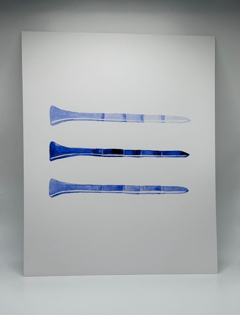 May include: Three watercolor paintings of blue golf tees on a white background.