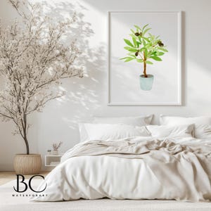 May include: A watercolour painting of a potted olive tree with green leaves and black olives. The painting is framed in a white frame and is hanging on a white wall above a white bed with a beige blanket.