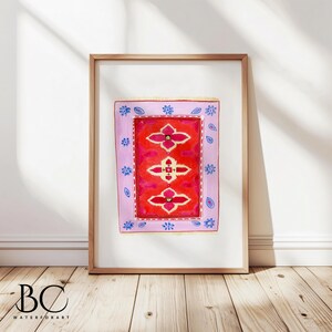 May include: A framed watercolor painting of a pink and red rug with a geometric pattern. The rug is surrounded by a blue and white border.
