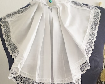 Bonito cuello jabot en algodón blanco y ribete de encaje blanco.