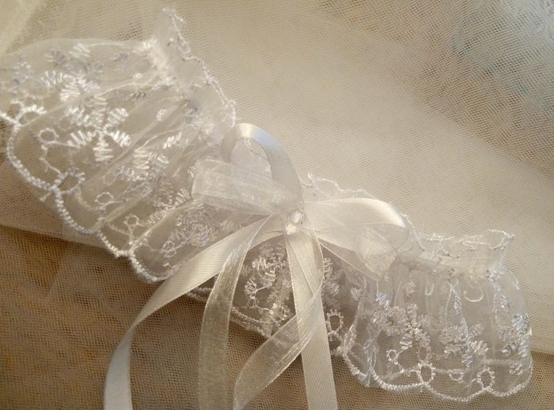 Jolie jarreti\u00e8re en organza sur brod\u00e9 fil de satin blanc