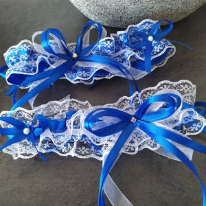 Pretty duo of white lace garters trimmed with royal blue satin ribbon bows