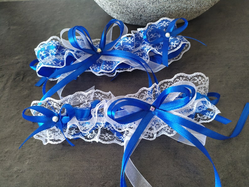 Pretty duo of white lace garters trimmed with royal blue satin ribbon bows image 1