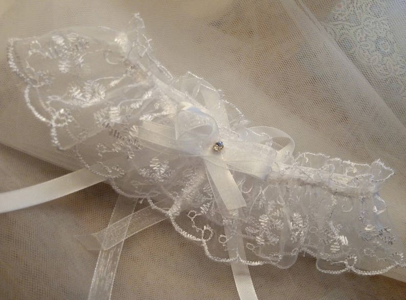 Jolie jarreti\u00e8re en organza sur brod\u00e9 fil de satin blanc