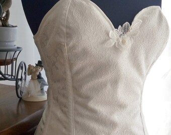 Pretty corset in brocade fabric with satin flower shapes in off-white/ecru color