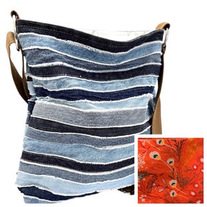 May include: A crossbody bag constructed from horizontal strips of blue denim in varying shades, featuring frayed edges and a brown strap. The interior lining is visible in a separate inset, displaying an orange fabric with a floral pattern.