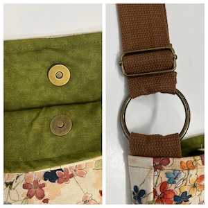 Puede incluir: Primer plano de una bolsa de tela verde con dos cierres magn&eacute;ticos de lat&oacute;n y una correa de lona marr&oacute;n con un anillo y una hebilla de lat&oacute;n.