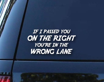 May include: A black car with a white vinyl sticker on the back window that reads "If I passed you on the right you're in the wrong lane."