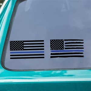 Puede incluir: Dos calcomanías de banderas americanas con una línea azul delgada. La bandera de la izquierda es una bandera estadounidense tradicional con una línea azul agregada debajo de las rayas. La bandera de la derecha es una bandera estadounidense desgastada con una línea azul agregada debajo de las rayas.