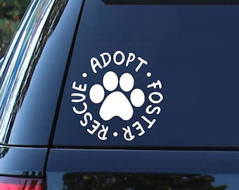 May include: White vinyl decal with a paw print in the center and the words "Adopt. Foster. Rescue." surrounding the paw print. The decal is on the back window of a black SUV.