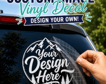 May include: A white circular vinyl decal featuring a mountain and forest graphic with the text "Your Design Here" applied to a car window. The decal has a clear transfer tape layer being peeled back. Text above reads "CUSTOM IMAGE Vinyl Decal DESIGN YOUR OWN!"